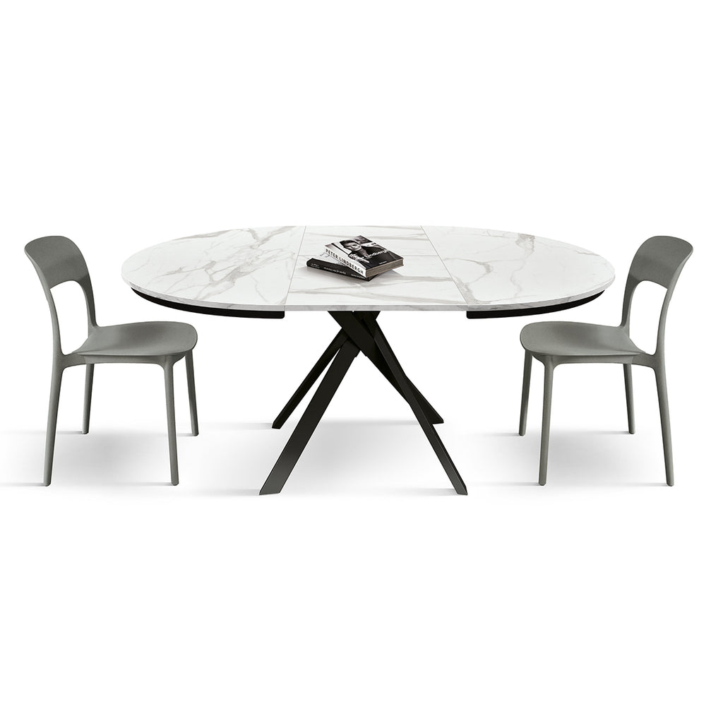 Tavolo Rotondo Allungabile Selene, vista laterale con sedie grigie e piano in ceramica marmo bianco Statuario