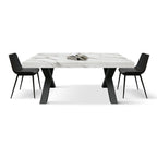 Tavolo Allungabile Andromeda, vista frontale con piano in marmo bianco Statuario, base a X nera e sedie nere